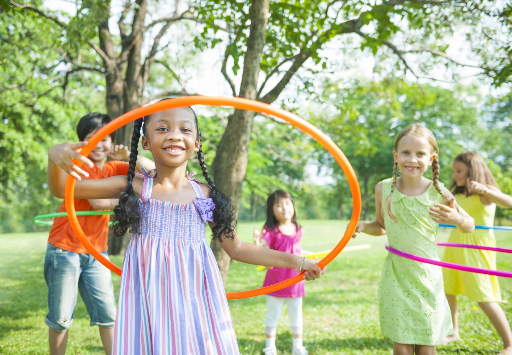 Group of children playing with hula hoops outside